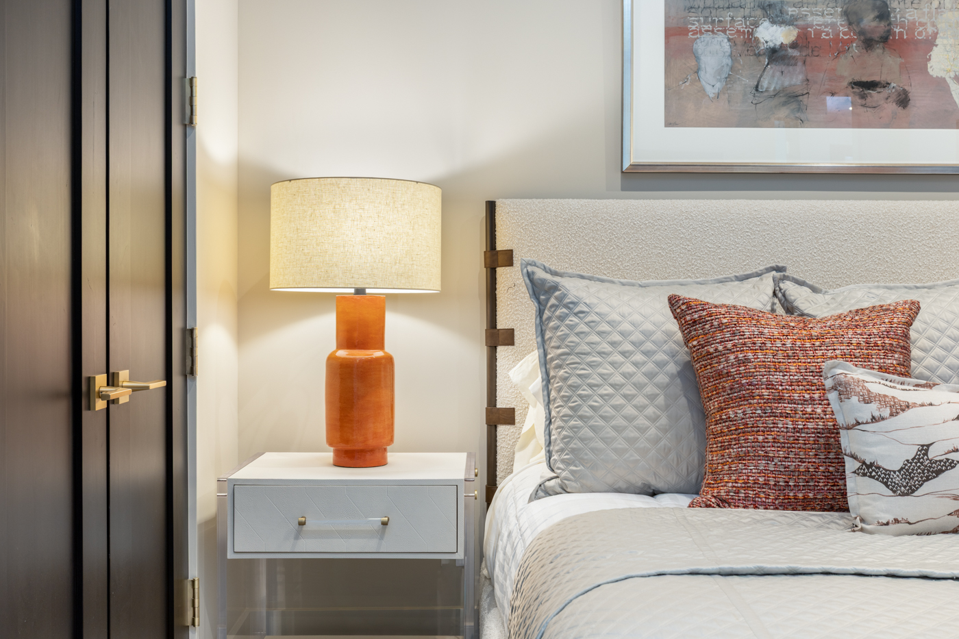 Bedside detail with orange ceramic lamp
