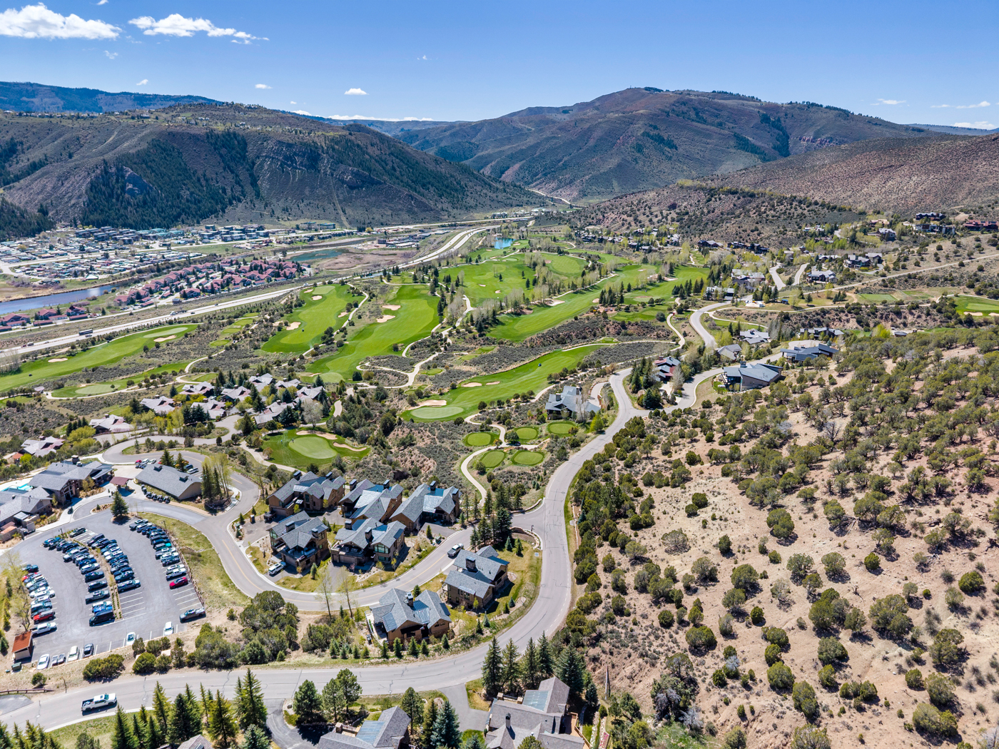Aerial over the golf course and surrounding peaks